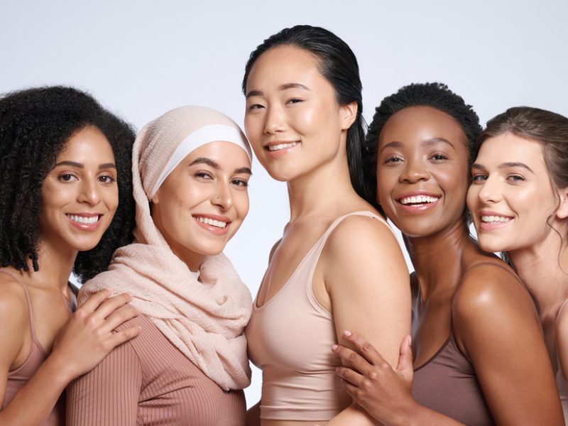 Diversity, woman and beauty portrait for body positive support, happiness and skincare wellness. Interracial models, happiness solidarity and smile for skin glow, cosmetics dermatology in studio